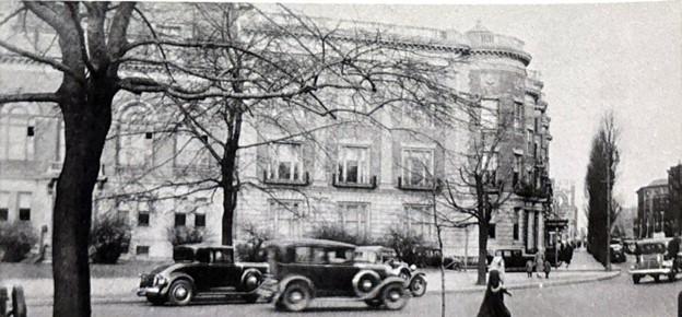 1932年马萨诸塞州历史学会大楼的黑白照片. Pedestrians and old cars pass by in the foreground.